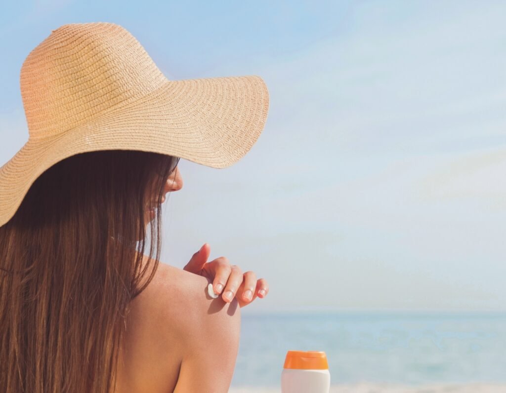 Woman applying sunscreen for a healthy Sun Tan